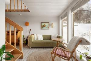 a living room with a green couch and a staircase at Alkove Apartment in Tromsø