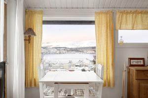 a white table and chairs in a room with a window at Alkove Apartment in Tromsø +16 photos