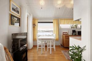 a kitchen and dining room with a table and a window at Alkove Apartment in Tromsø