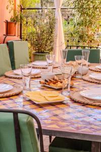 a table with plates and glasses and food on it at Luxury Villa with Pool, Garden & Gated Security in Marrakech