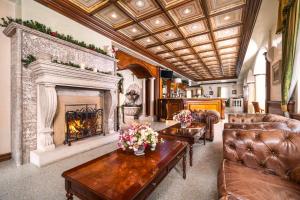 a living room with a fireplace and leather furniture at Festa Winter Palace Hotel in Borovets