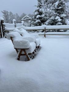 eine Gruppe von Bänken mit Schnee neben einem Zaun in der Unterkunft Il Cottage in Castel di Sangro + 51 Fotos