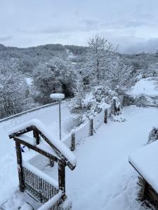einen schneebedeckten Balkon mit Bäumen im Hintergrund in der Unterkunft Il Cottage in Castel di Sangro