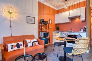 a living room with a couch and a table at Déborah studio calme lit et place de parking in Rouen