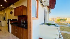 a kitchen with a sink and a window with a view at Stay10 Parallel Apartment Hotel in Indore