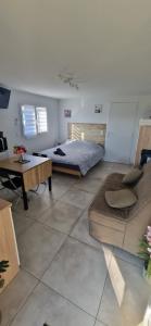 a bedroom with a bed and a table and a couch at Studio plein Sud au calme in Montauban