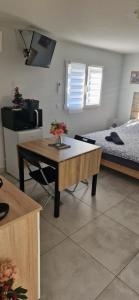 a living room with a table and a bed at Studio plein Sud au calme in Montauban