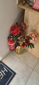 a brass vase with flowers on the floor in a room at Studio plein Sud au calme in Montauban