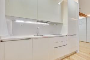 a white kitchen with white cabinets and a sink at La Chapitela 7 by Clabao in Pamplona +16 photos