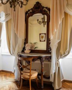 a dressing table with a mirror and a chair at Palazzo Lari Sarzana in Sarzana