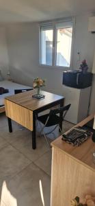 a room with a table with a vase of flowers on it at Studio plein Sud au calme in Montauban