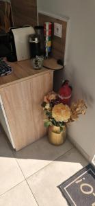 a counter with a vase of flowers in a kitchen at Studio plein Sud au calme in Montauban