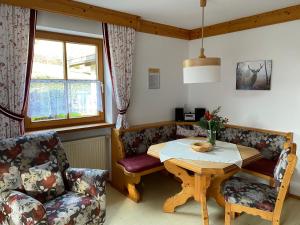 een woonkamer met een tafel en een bank bij Haus am Wiesbach in Reit im Winkl
