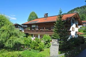een groot huis met een bord ervoor bij Haus am Wiesbach in Reit im Winkl