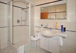een witte badkamer met douche en wastafel bij Haus am Wiesbach in Reit im Winkl +41 foto's