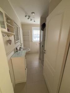 a white bathroom with a sink and a shower at Heidelandhaus Zühlke mit gemütlicher Südterrasse in Soltau