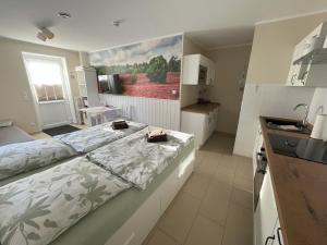 a bedroom with a large bed and a kitchen at Heidelandhaus Zühlke mit gemütlicher Südterrasse in Soltau