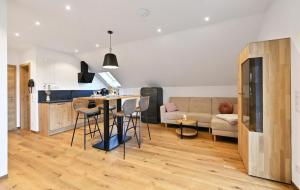 a kitchen and living room with a table and a couch at Landhaus Ingeborg in Poppenhausen