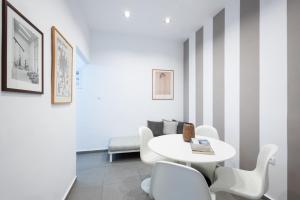 a dining room with a white table and chairs at Renovated 5 Bdr House near Acropolis - New Beds, Terrace & Green Yard in Athens