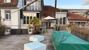 una casa con un patio con una lona verde en The R Loft - Cosy Hostel, Communal Bathroom and Kitchen, en Olten
