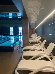 ヴロツワフにあるMotylkowa 125 m2 Apartament 5 pokoiの白い椅子の並ぶスイミングプール