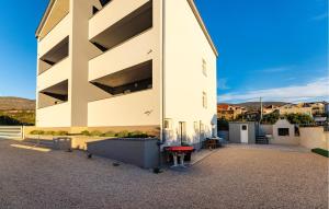 a white building with a red bench in front of it at Stunning Apartment In Gornji Karin in Gornji Karin