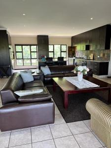 a living room with couches and a table and a kitchen at Wild Antelope on your doorstep! in Nelspruit