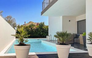 una piscina con tres macetas junto a una casa en 5 Bedroom Beautiful Home In Stinjan, en Štinjan 30 fotos más