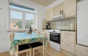 a kitchen with a table and a stove and a window at 2 Bedroom Nice Home In Roslev in Roslev +17 photos