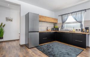 cocina con armarios negros y nevera de acero inoxidable en 5 Bedroom Beautiful Home In Stinjan, en Štinjan