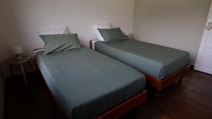 two beds sitting next to each other in a room at Maison pieds dans l'eau - Villa Veloutier in Saint-Paul