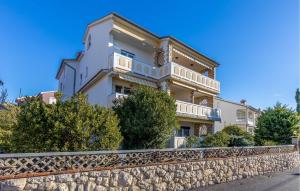 un grand bâtiment blanc derrière un mur de pierre dans l'établissement Awesome Apartment In Palit With Wifi, à Palit