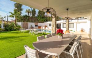 a patio with a white table and chairs and a yard at Amazing Villa With Heated Pool in Benalmádena