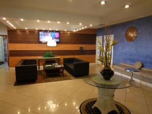 a living room with a couch and a tv at Red Carpet Inn Airport Fort Lauderdale in Fort Lauderdale