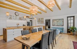 a kitchen and dining room with a wooden table and chairs at Nice Home In Odder With House Sea View in Odder