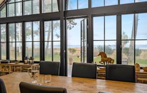 a dining room with a table and a horse statue in front of windows at Nice Home In Odder With House Sea View in Odder