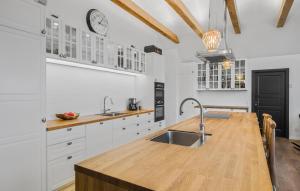 a kitchen with white cabinets and a wooden counter top at Nice Home In Odder With House Sea View in Odder +11 photos