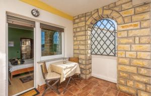 une salle à manger avec une table et un mur en pierre dans l'établissement Nice Apartment In Palit With Wifi, à Palit