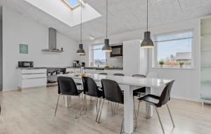 ボーゲンセにあるGorgeous Home In Bogense With Wifiのダイニングテーブルと黒い椅子のある白いキッチン