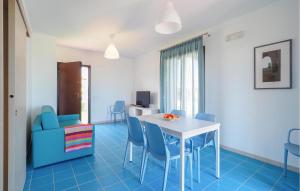 ein Wohnzimmer mit einem Tisch und blauen Stühlen in der Unterkunft 2 Bedroom Lovely Home In Marina Di Modica in Marina di Modica
