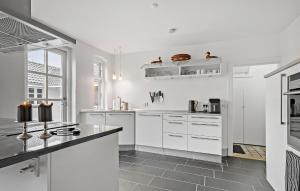 kuchnia z białymi szafkami i czarnym blatem w obiekcie 3 Bedroom Stunning Home In Rødby w mieście Rødby