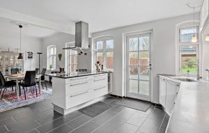 kuchnia z białymi szafkami i jadalnią w obiekcie 3 Bedroom Stunning Home In Rødby w mieście Rødby +8 zdjęć