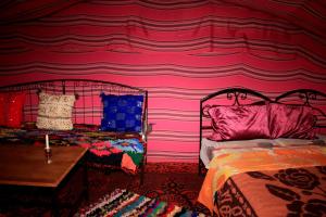 Katil atau katil-katil dalam bilik di Bivouac Le Petit Prince Merzouga