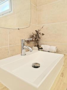 Un lavabo blanco en un baño con espejo. en Appartement le loft, en Saintes-Maries-de-la-Mer 20 fotos más