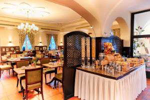a restaurant with tables and chairs and a bar at Hotel SchreiberHof in Aschheim