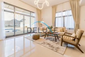 a living room with a couch and a table at Special Rate with Temp Controlled Pool, BBQ & Maid's by Deluxe Holiday Homes in Fujairah