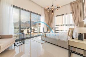 a bedroom with a large bed and a table at Special Rate with Temp Controlled Pool, BBQ & Maid's by Deluxe Holiday Homes in Fujairah