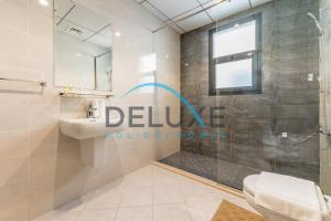 a bathroom with a shower and a toilet and a sink at Special Rate with Temp Controlled Pool, BBQ & Maid's by Deluxe Holiday Homes in Fujairah
