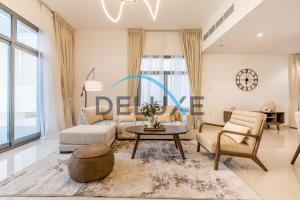 a living room with a couch and a table at Special Rate with Temp Controlled Pool, BBQ & Maid's by Deluxe Holiday Homes in Fujairah