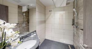 a bathroom with a sink and a shower at PLAZA INN Heilbronn in Heilbronn +40 photos